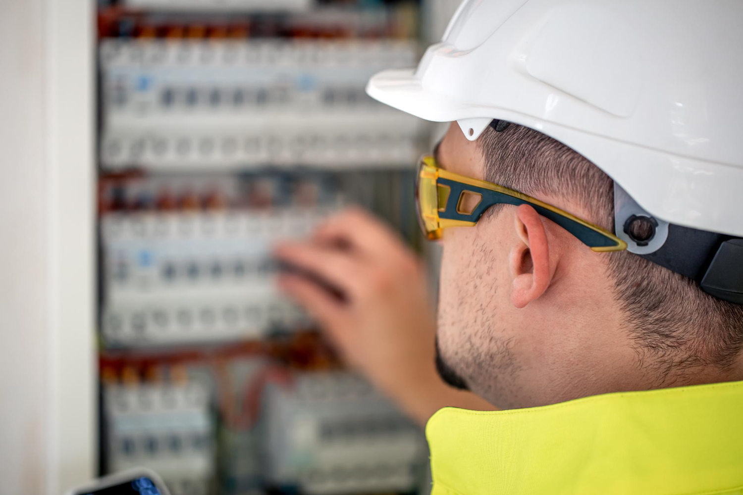 Electrical Technician Looking Focused While Working Switchboard With Fuses